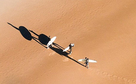 冲浪爱好者在沙滩行走壁纸