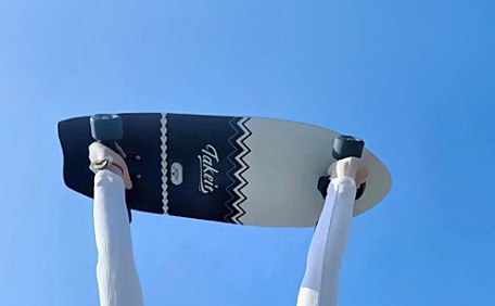 美女在天空下举着滑板壁纸