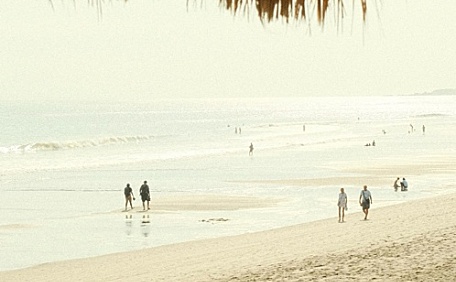 海边稻草棚下沙滩海水海面阴天风景壁纸