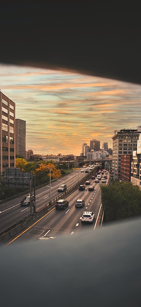 火烧云黄昏下的城市建筑公路上的汽车风景壁纸