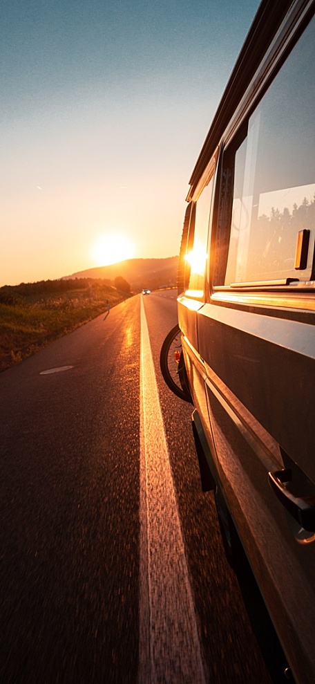 夕阳黄昏公交车在公路上草坪壁纸