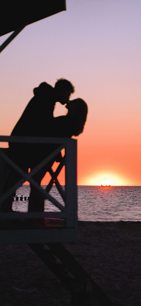夕阳黄昏海面海边小屋情侣热吻壁纸