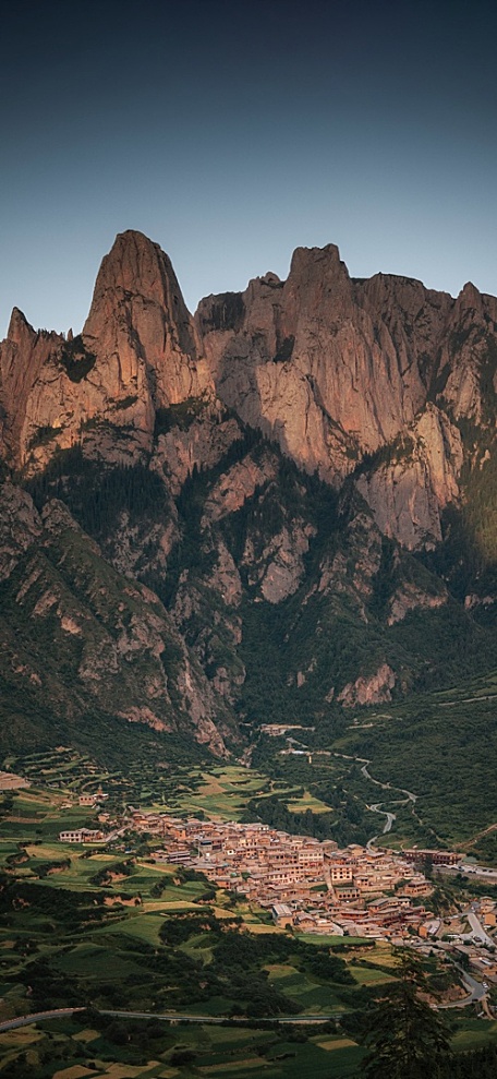 深夜蓝天下的岩石山丘山下的小镇风景壁纸